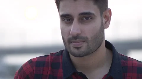 Closeup shot of serious man face looking at camera while standing outdoor alone. Video stock 148921998