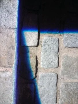 Closeup shot of shadows covering a surface made of rectangular stones Foto stock