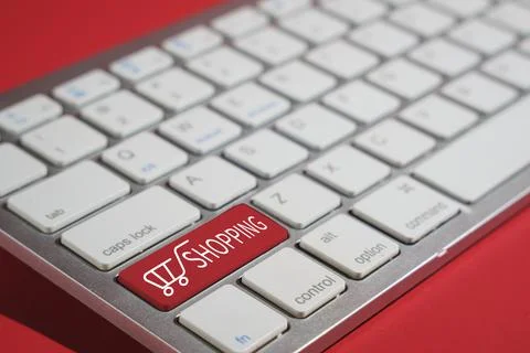 Closeup shot of shopping text on a computer keyboard isolated on red background Foto stock