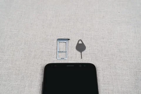 Closeup shot of Sim card tray, eject tool, smartphone Stock Photos