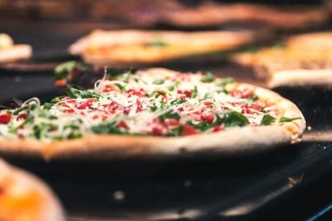 Closeup shot of a slice of pizza with vegetables and cheese on the table Foto stock