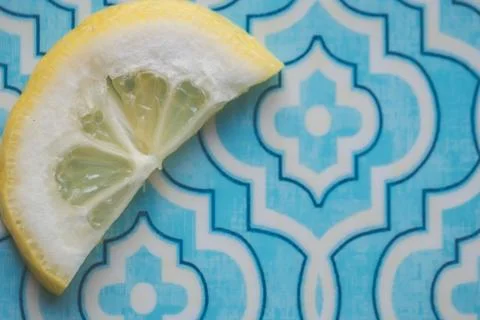 Closeup shot of sliced lemon on a patterned blue background wallpaper Stock Photos