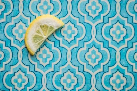 Closeup shot of sliced lemon on a patterned blue background wallpaper Stock Photos