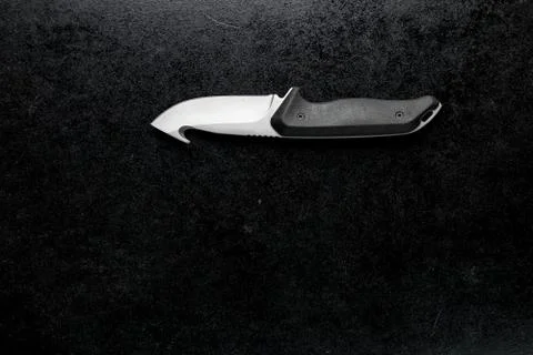 Closeup shot of a small sharp knife with a black handle on a black background 스톡 사진