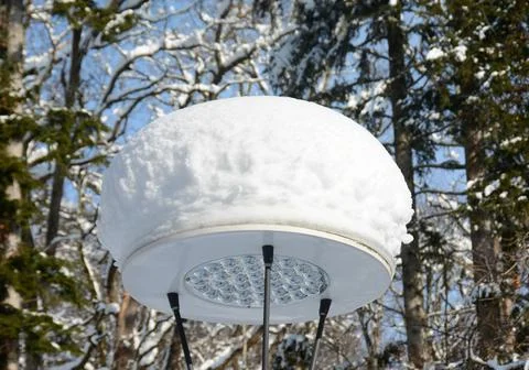 Closeup shot of a snow stack on the circular lantern in the park Stock Photos