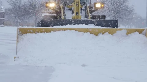 Closeup shot of snowplower removing extra snow from parking lot surfaces. Stock Footage 302773711