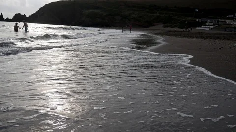 Closeup shot of soft gentle waves coming into shore, sunset Stock Footage 114481326