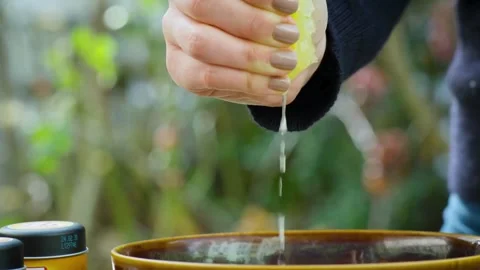 Closeup shot of squeezing yellow ripe lemon with hand, releasing abundant l.. Stock Footage 265838448