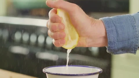 Closeup shot of squeezing yellow ripe lemon with hand, releasing abundant l.. Stock Footage 265838538