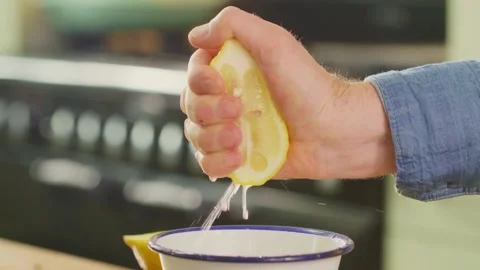 Closeup shot of squeezing yellow ripe lemon with hand, releasing abundant lemon Stock-Footage 336588589