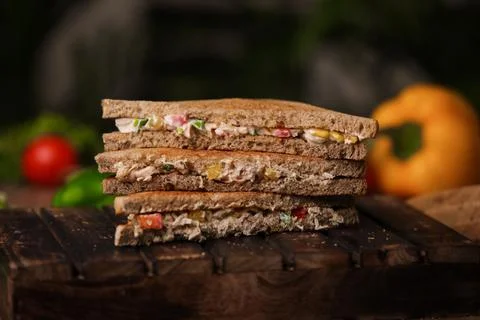 Closeup shot of a stack of cut triangle sandwiches with meat and vegetables near Foto stock