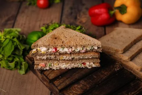 Closeup shot of a stack of cut triangle sandwiches with meat and vegetables Foto stock