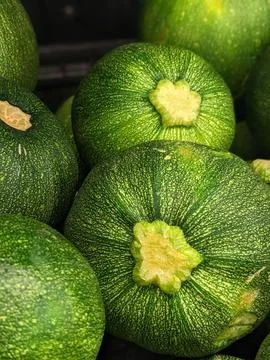 Closeup shot of a stack of fresh, green zucchini arranged in a neat pile on a wh Foto stock