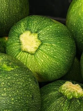 Closeup shot of a stack of fresh, green zucchini arranged in a neat pile on a wh Stock Photos