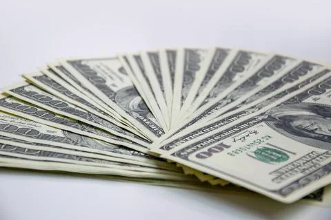 A closeup shot of a stack of new, hundred-dollar bills fanned out on a plai.. Stock Photos
