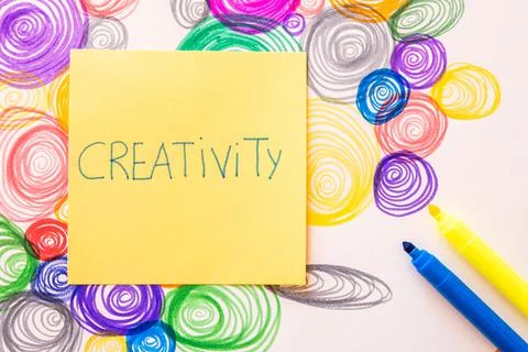 A closeup shot of a sticky note with "Creativity" writing on colorful spiral  Stock Photos