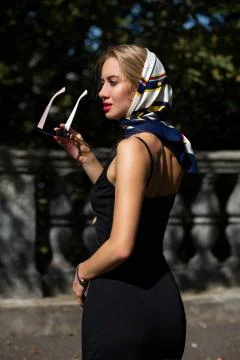 Closeup shot of stylish model with red lips wearing shawl and black dress pos Stock Photos