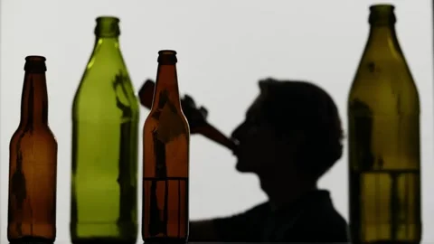 In the closeup shot, there are empty, dissipated glass bottles with alcohol in Stock Footage 252406724