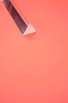 Closeup shot of a triangular glass prism isolated on a red background Stock Photos