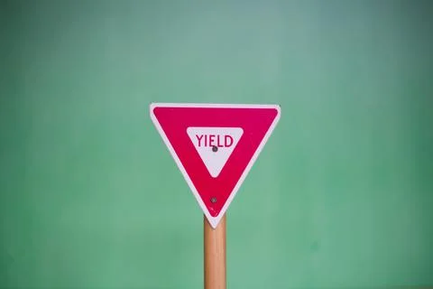 Closeup shot of a triangular "Yield" sign on a blurred background 스톡 사진
