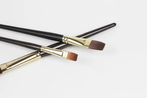 Closeup shot of a two small size flat brush placed above the other brush Stock Photos