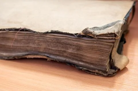 Closeup shot of a vintage aged weathered book with torn pages Stock Photos