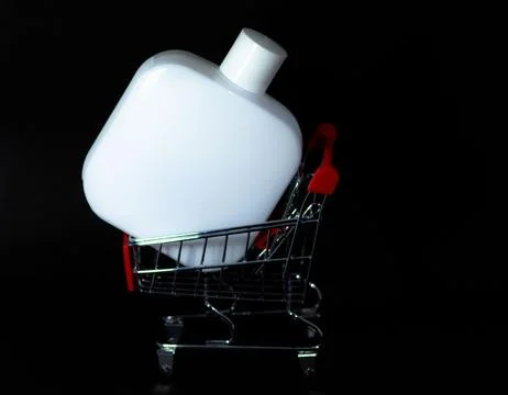 Closeup shot of a white bottle in a tiny supermarket cart Foto stock