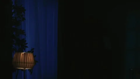Closeup shot of the window in the dark room, thunder outside, man maniac in mask Stock Footage 250419043