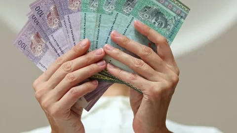 Closeup shot of woman's hands and Malaysian ringgit (MYR) banknotes. Stock Footage 307963765