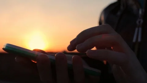 Closeup shot of women hands using mobile phone, beautiful sunset city background Stock Footage 74943741