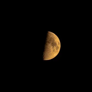 Closeup shot of yellow moon eclipse isolated on a black background Fotos Stock