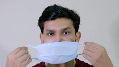 Closeup shot of a young boy using a medical mask during the Covid-19 pandemic 스톡 동영상 132388823
