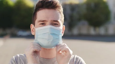 Closeup shot of a young man using a medical mask during the Covid-19 pandemic Stock Footage 171414468