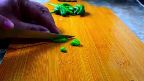 Closeup Side Angle Shot of Cutting Green Chilies on Wooden Cutting Board HD Stock Footage 149381644