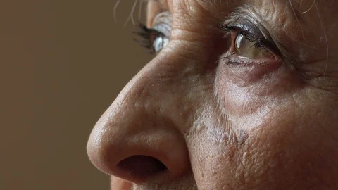 Closeup side portrait of an old woman's eyes: pensive depressed elderly woman Stock Footage 91702169