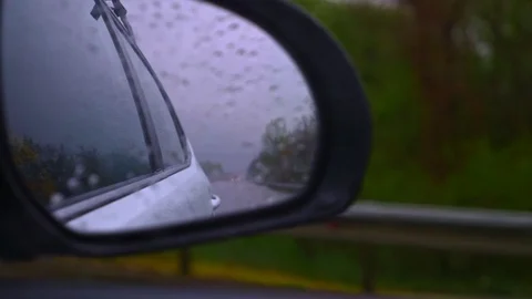 Closeup. side rear view mirror of the car in the rain while driving Stock Footage 129256578