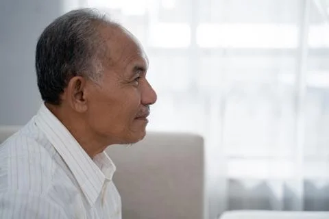 Closeup from side view of Asian old man sitting on the sofa Stock-Fotos