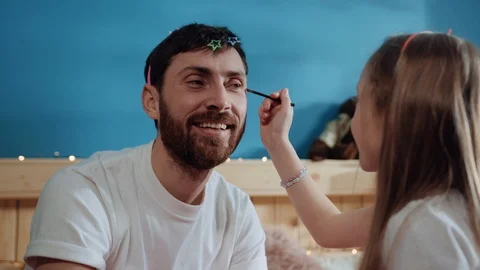 Closeup side view happy little girl putting cosmetics with brush on her dad's Stock Footage 112256726