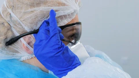 Closeup side view of medical worker puts on safety glasses. 動画素材 128376427