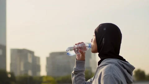 Closeup side view portrait of pretty young woman in hijab and activewear Stock Footage 218070457