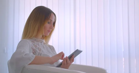 Closeup side view portrait of young pretty caucasian businesswoman using the Video stock 111943688