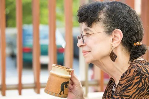 Closeup side view profile portrait, grandmother enjoying cup of drink, isolat Foto stock