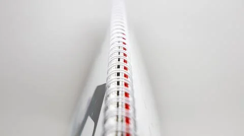 A closeup, side view of a spiral-bound notebook or calendar, focusing on th.. Stock Photos