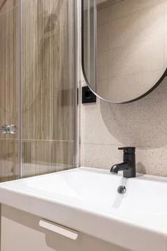 Closeup side view of white durable ceramic sink on vanity top with matt black Stockfoto's