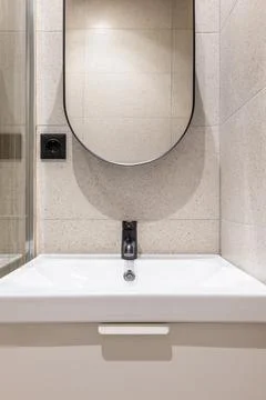 Closeup side view of white durable ceramic sink on vanity top with matt black Photos