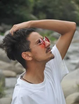Closeup side view of a young guy standing beside of river  Foto stock