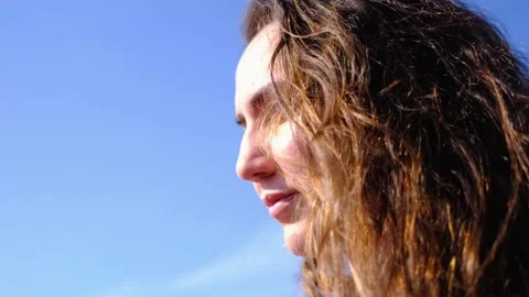 Closeup side view of young pretty caucasian girl looking at far away with sky Stock Footage 131043817
