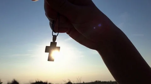 Closeup Of Silhouette Cross Hanging at sunset/sunrise time Stock Footage