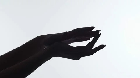 Closeup of the silhouette of woman's hands on white background, runs finger Stock Footage 167257341