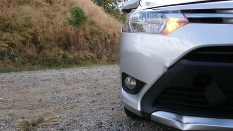 Closeup of silver car front damaged by crash accident with headlight flashing Stock Footage 164516804